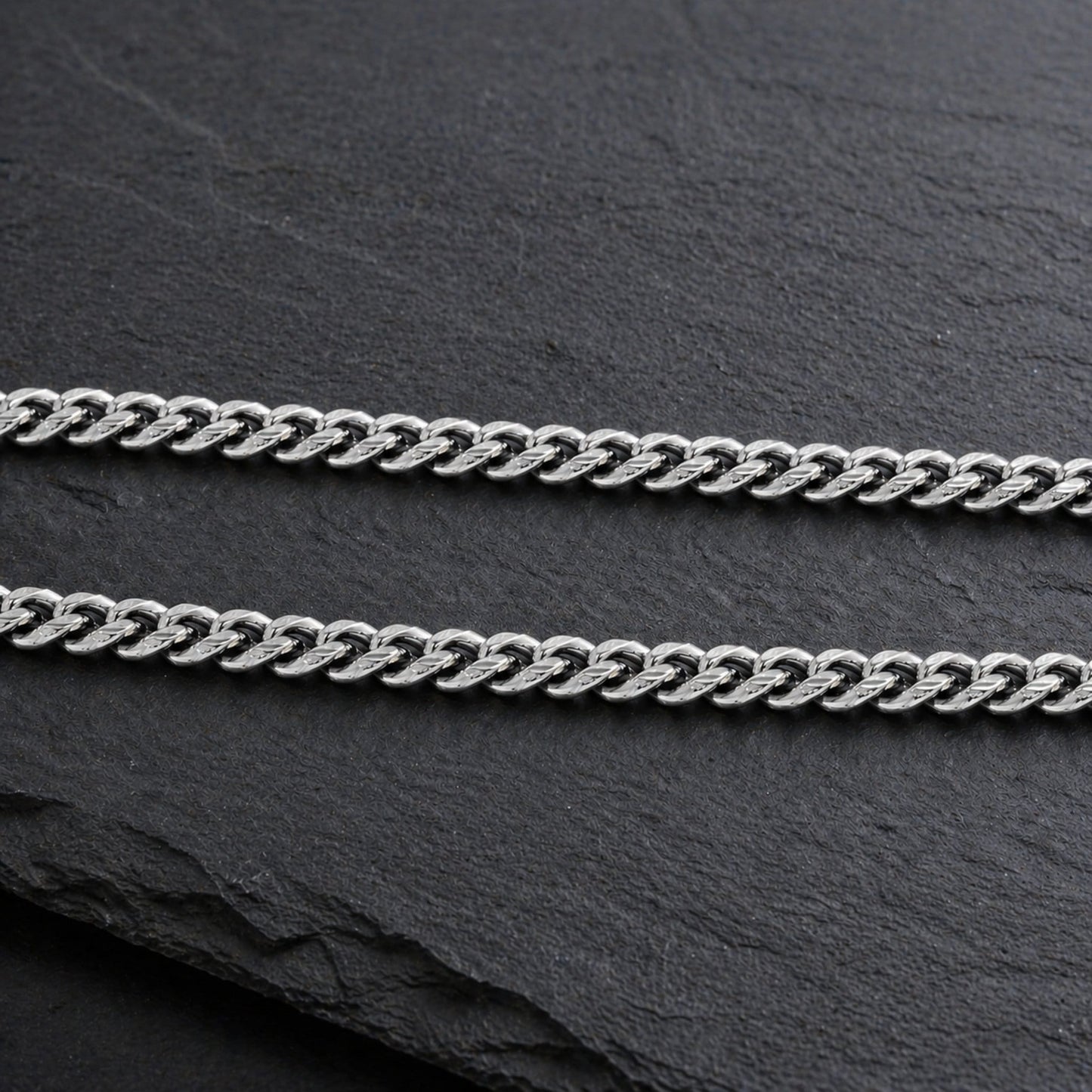 silver cuban link chain on slate background