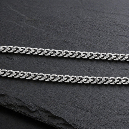 silver cuban link chain on slate background