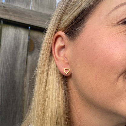 close up of home plate shaped earrings in gold color. 
