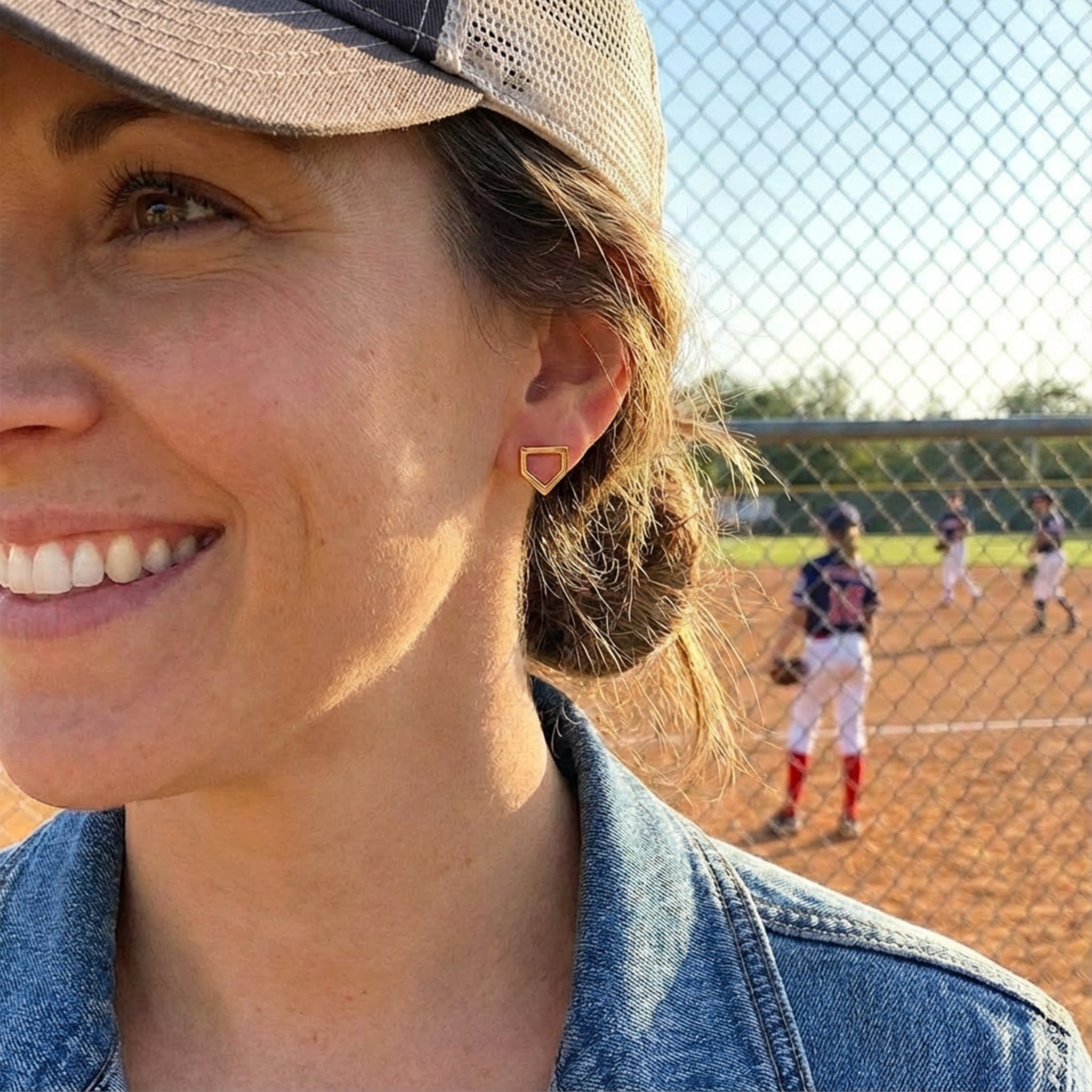 woman wearing home plate shaped earrings