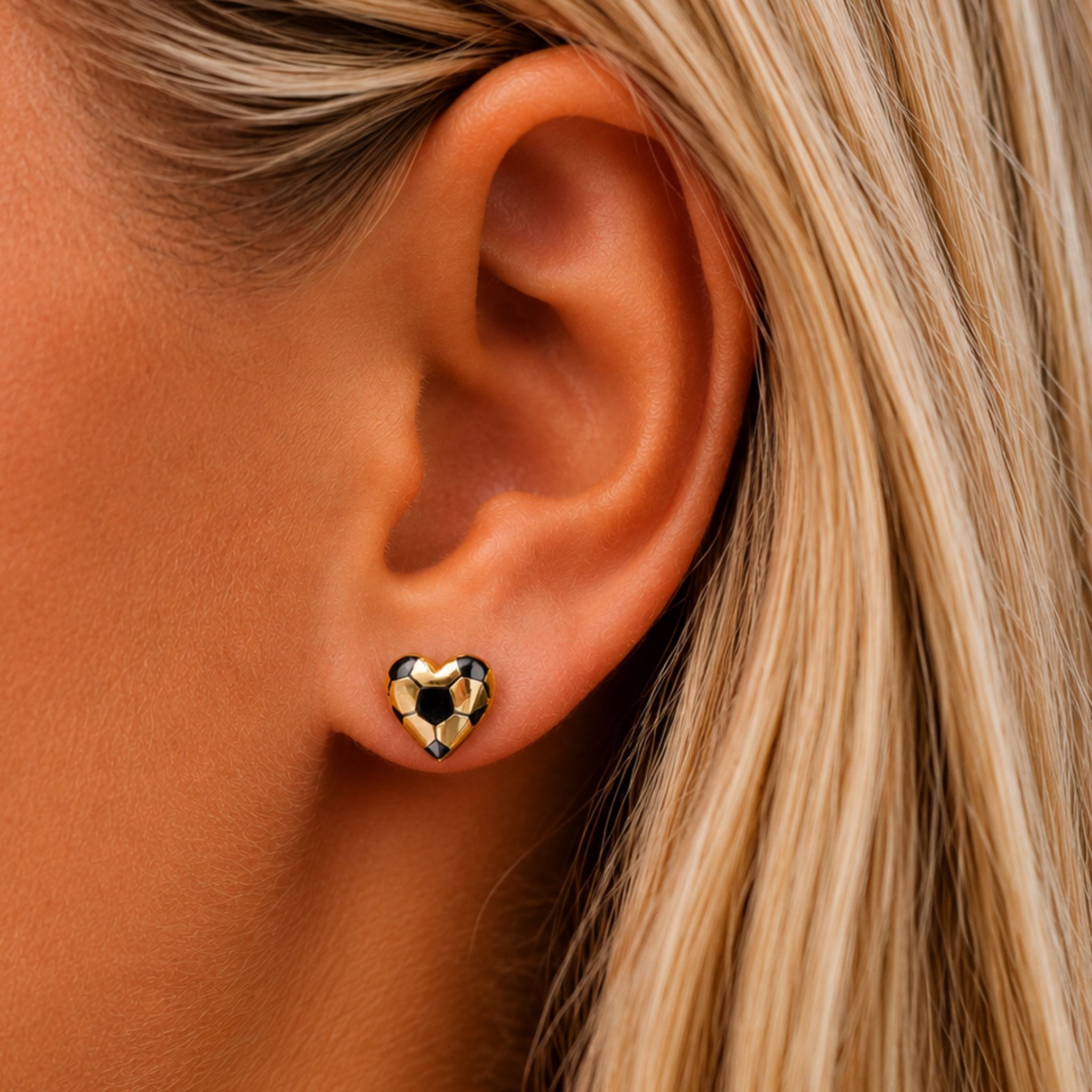 woman wearing soccer earrings shaped like a heart